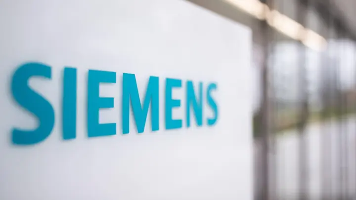 Das Schriftzug-Logo des deutschen Industriekonzerns Siemens, steht auf einer Stele am Eingang eines Bürogebäudes auf dem Siemens Campus Erlangen. (Foto: Daniel Karmann/dpa/Bildarchiv)