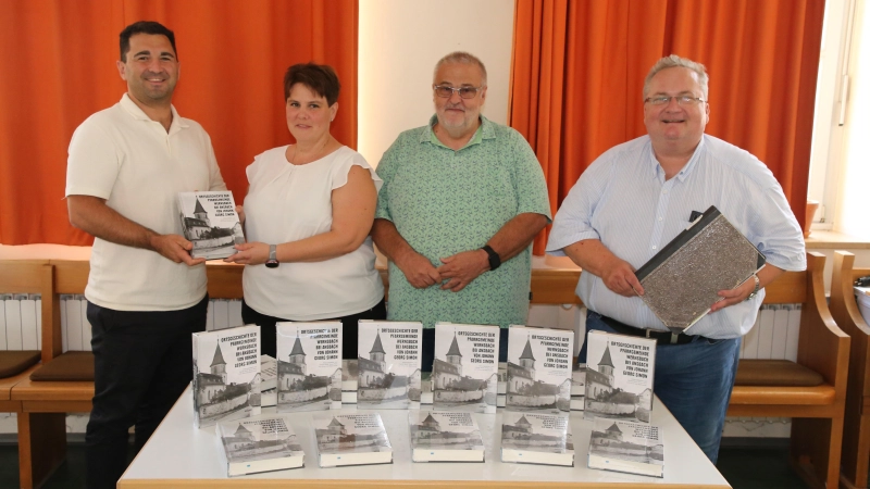 Weihenzells Bürgermeister Volkan Mertkan erhielt eines der ersten Exemplare der Ortsgeschichte der Pfarrgemeinde Wernsbach von den Herausgebern Heike Horn, Harald Beck und Pfarrer Dr. Johannes Wachowski (von links).  (Foto: Alexander Biernoth)