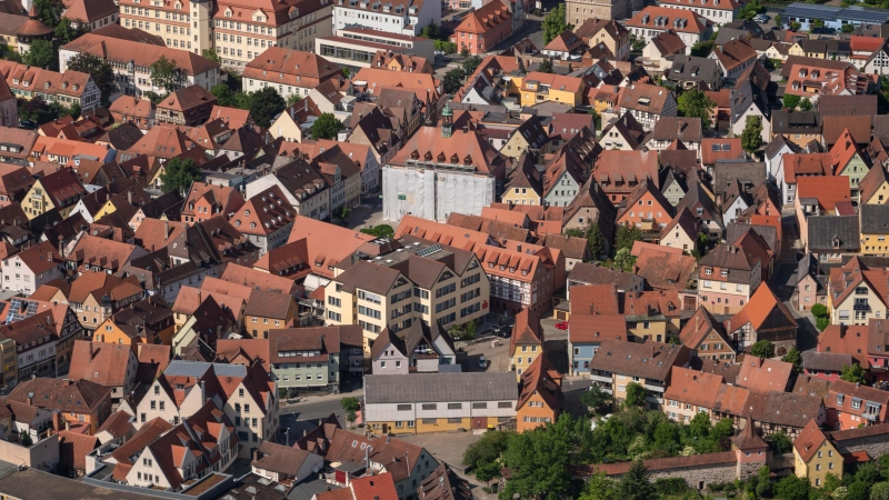 Von oben sieht es tatsächlich aus wie ein Christo-Kunstwerk – Neustadts verhülltes Rathaus in der Bildmitte. Am 10. und 11. Juni wird das Gerüst abgebaut und die Fassade „enthüllt“. (Foto: Johann Schmidt)