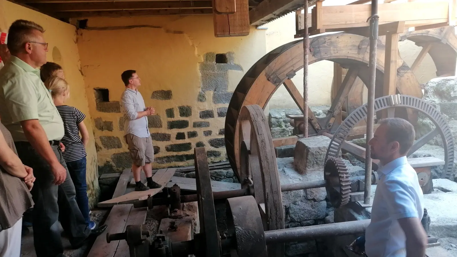 Mühlenbesitzer Florian Maier (Zweiter von rechts) erläutert den Besuchern des Tages der offenen Tür die Funktionsweise der Mühlräder. Zu den Zuhörern gehörten Bürgermeister Thomas Beck (rechts) und stellvertretender Landrat Stefan Horndasch (links). (Foto: Friedrich Zinnecker)