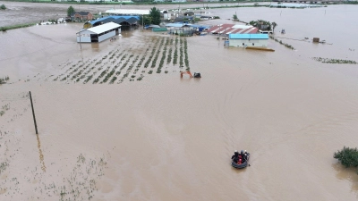 Rettungskräfte suchen auf einem Boot nach vermissten Personen im Hochwasser, nachdem der Tropensturm „Khanun“ auf Land getroffen ist. (Foto: Yun Kwan-shick/Yonhap/AP/dpa)