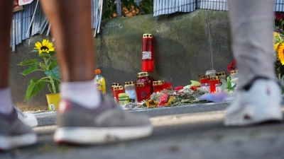 Menschen stehen in Dortmund vor einem Zaun, an dem mit Kerzen und Blumen des von der Polizei erschossenen Jugendlichen gedacht wird. (Foto: Gregor Bauernfeind/dpa)
