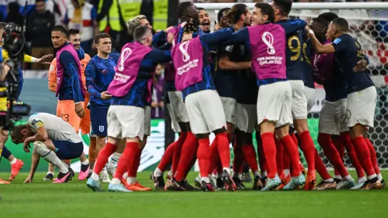 Die französischen Spieler feiern den Sieg, Englands Harry Kane (l) kauert auf dem Rasen. (Foto: Robert Michael/dpa)