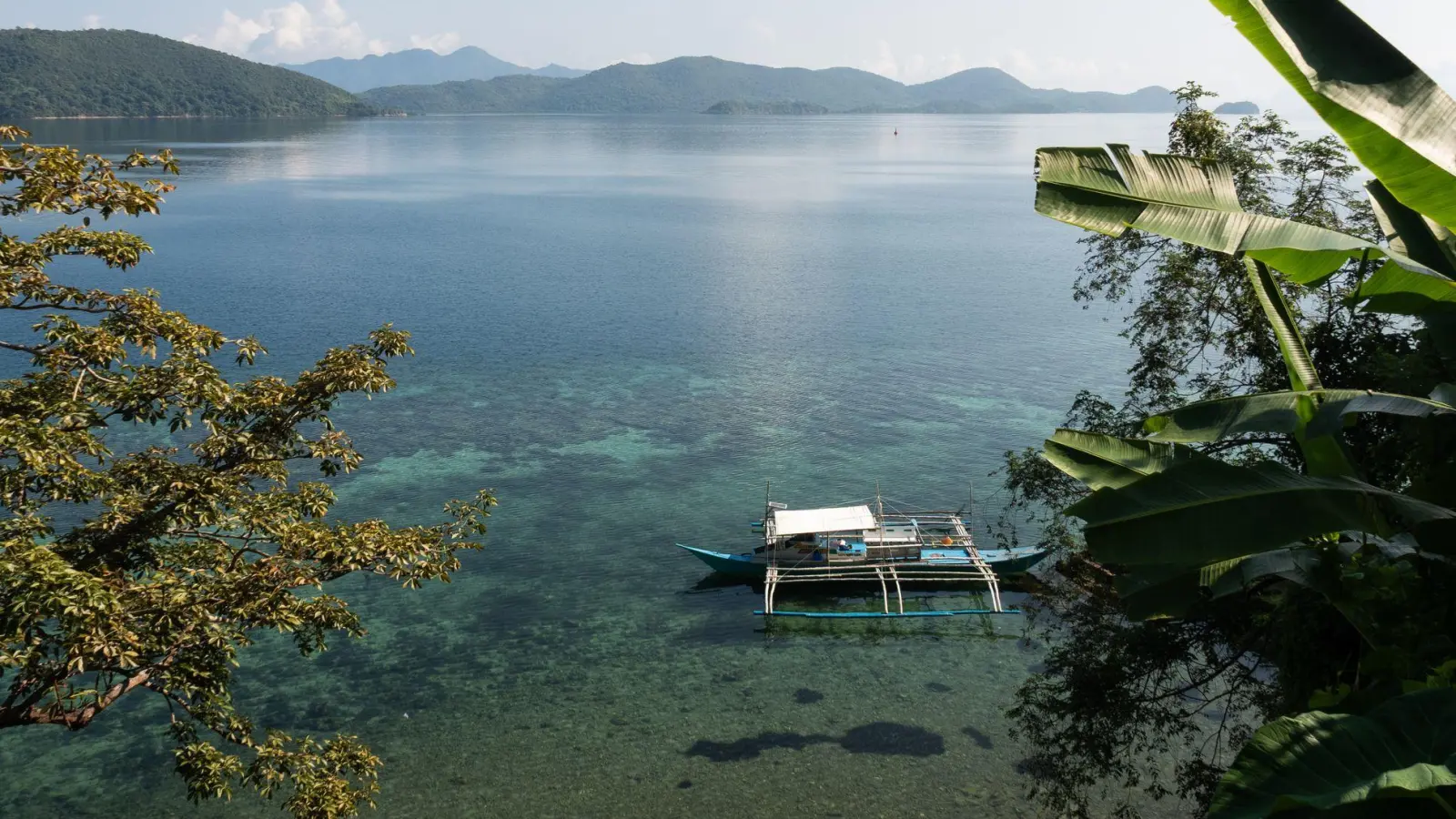 Im Wasser schaukelt ein Auslegerboot, eine Brise raschelt in den Palmblättern: So sieht ein verlorenes Inselparadies aus. (Foto: Andreas Drouve/dpa-tmn)