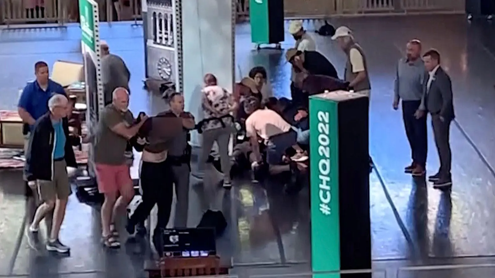 Videostandbild vom Moment nach der Attacke in der Chautauqua Institution: Der mutmaßliche Angreifer (l) wird von der Bühne eskortiert, während sich Menschen um Salman Rushdie kümmern. (Foto: Uncredited/AP/dpa)