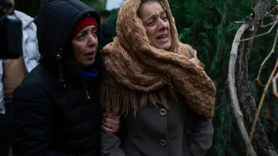 Frauen weinen, während sie zusehen, wie die Rettungskräfte in den Trümmern eines zerstörten Gebäudes in Adana nach Menschen suchen. (Foto: Khalil Hamra/AP/dpa)