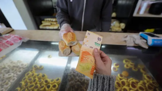 Eine Frau zahlt mit einem 1000-Peso-Schein in einer Bäckerei. (Foto: Claudio Santisteban/dpa)