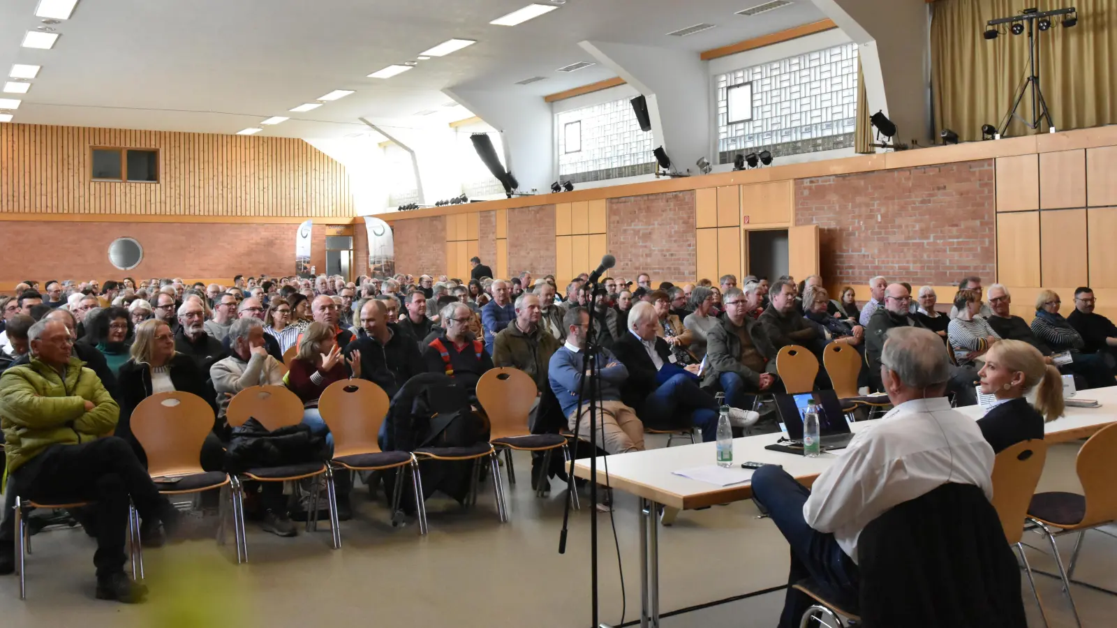 Die Wolfgang-Graf-Halle in Scheinfeld war am Sonntag voll. Am Tisch die Hauptreferentin des Projektierers, Geschäftsführerin Katrin Held von der Naturenergie Zeilinger (rechts), daneben ihr Vater Reinhold Zeilinger. (Foto: Anita Dlugoß)