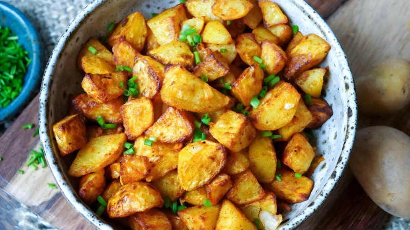 Nur kleine Mengen Fett bekommen Bratkartoffeln per Ölsprüher ab, werden mit Salz und Paprikapulver gewürzt und kommen in den Airfryer: Nach 25 Minuten sind die Kartoffelstücke richtig schön knusprig. (Foto: Steffi Sinzenich/gaumenfreundin.de/dpa-tmn)