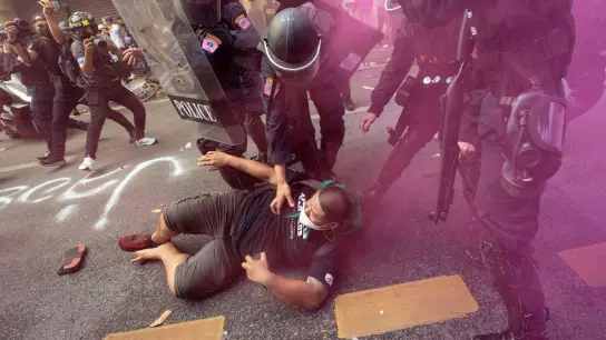 Polizisten entfernen einen Demonstranten, der zusammen mit weiteren versucht zum Veranstaltungsort des Apec-Gipfels zu gelangen. (Foto: Wason Wanichakorn/AP/dpa)