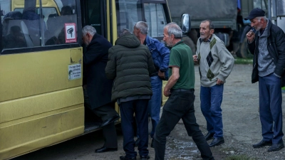 Ethnisch-armenische Männer steigen im Oktober in einen Bus nach Goris in Armenien ein. (Foto: Aziz Karimov/AP/dpa)