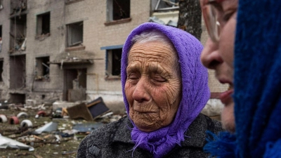 Frauen stehen in Lukiantsi in der Region Charkiw vor einem Haus, das durch einen russischen Luftangriff schwer beschädigt wurde. (Foto: Evgeniy Maloletka/AP/dpa)