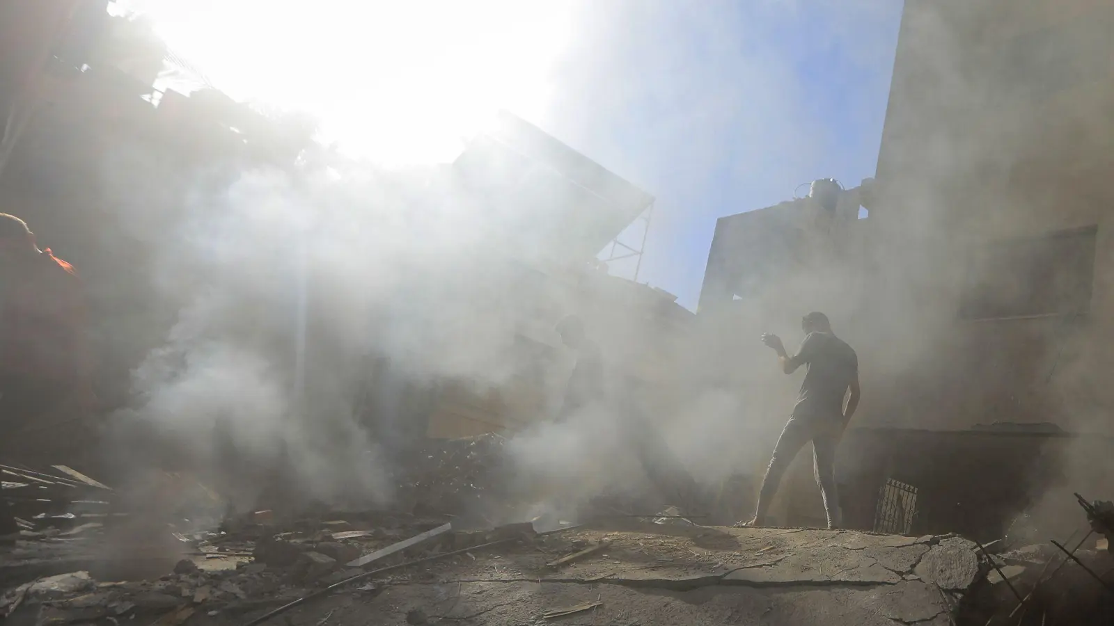 Palästinenser und Mitarbeiter des Zivilschutzes suchen in den Trümmern eines zerstörten Gebäudes nach einem israelischen Luftangriff auf Chan Junis nach Überlebenden. (Foto: Mohammed Talatene/dpa)