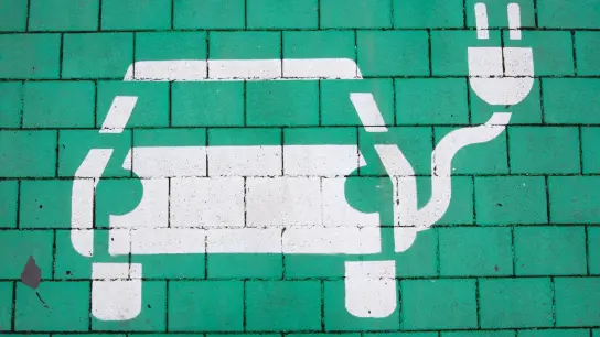Ein Elektroauto auf grünem Grund markiert einen Parkplatz für Elektrofahrzeuge. (Foto: Julian Stratenschulte/dpa/Symbolbild)