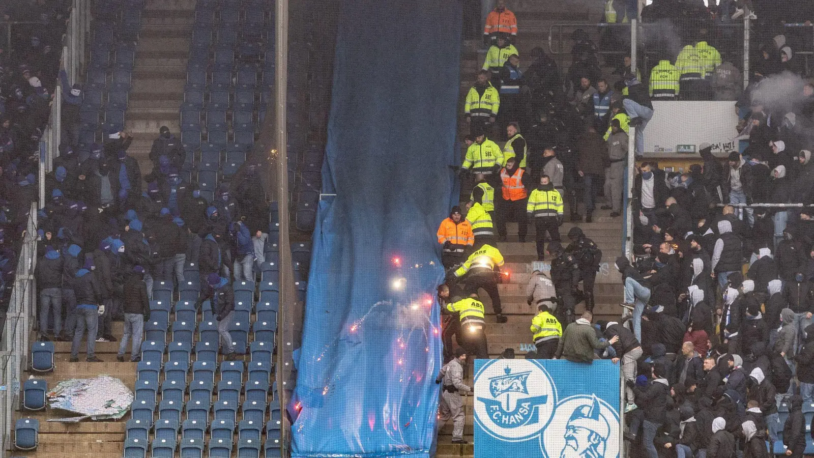 Ordner versuchen die Fans beider Vereine wieder in die Blöcke zurück zu drängen. (Foto: Axel Heimken/dpa)
