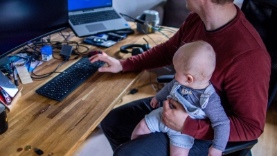 Ein junger Vater im Home-Office mit seinem sechs Monate alten Sohn. (Foto: Jens Büttner/dpa)