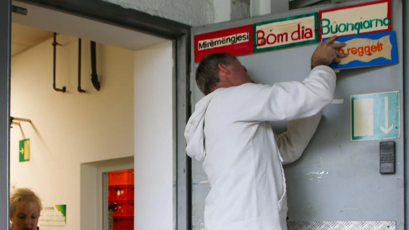 Klassleiter Harald Simon befestigte die Schilder an der Tür. Elke Böhm, die Sprecherin des Dinkelsbühler Tischs, freute sich über das Ergebnis des Kunstprojekts. (Foto: mk)