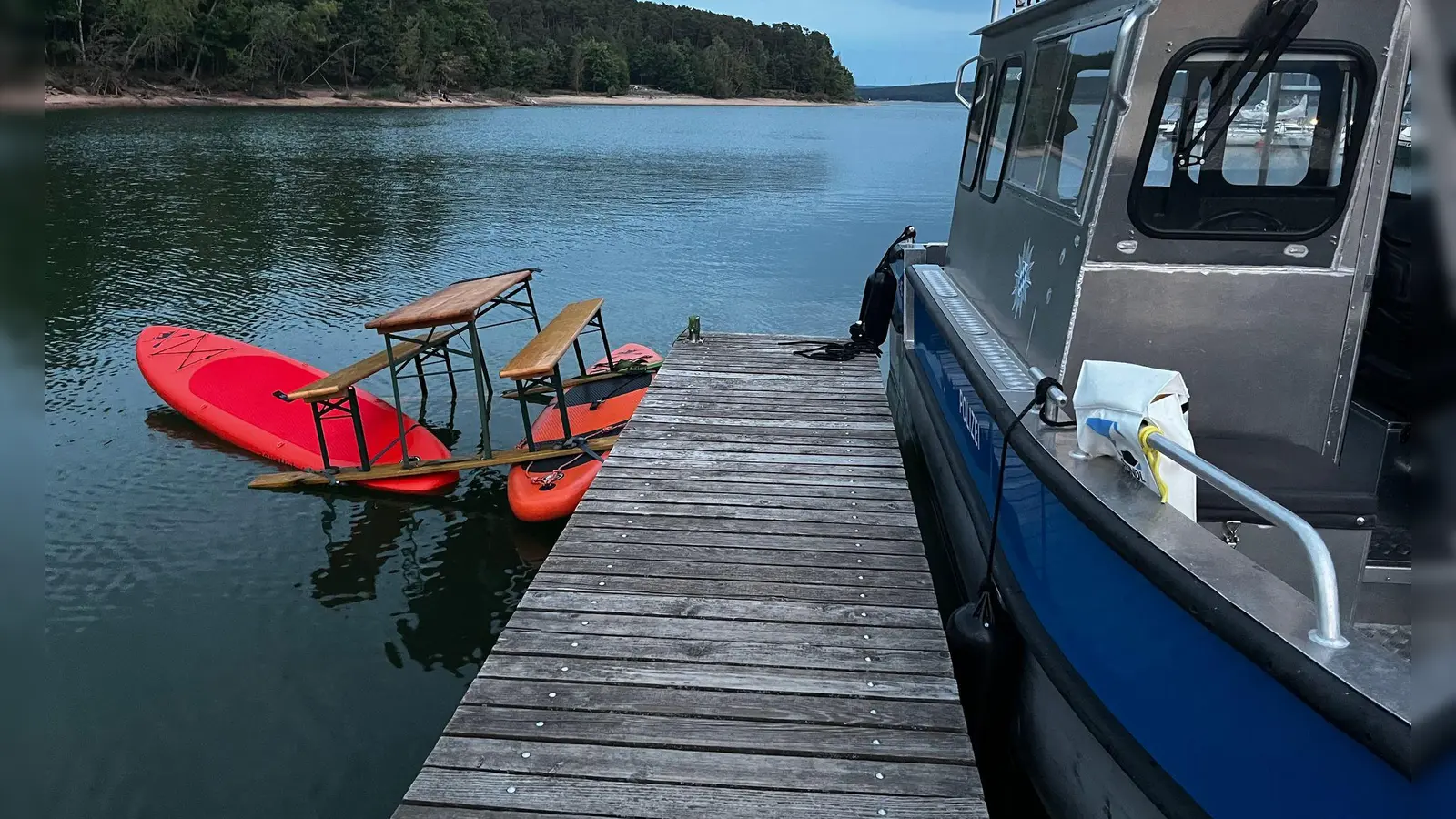 Das Trio war auf einer Konstruktion aus Surfbrettern und einer Bierbank auf dem Brombachsee unterwegs. Bild: Polizei Mittelfranken (Foto: -/Polizei Mittelfranken/dpa)