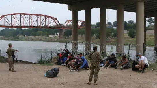 Migranten warten am Rio Grande auf die Ankunft von US-Grenzschutzbeamten. Eine Regelung der Gesundheitsbehörde CDC ermöglicht unter Verweis auf pandemiebedingte Gesundheitsrisiken, die meisten ohne gültige Papiere ins Land gelangten Menschen rasch wieder abzuschieben. (Foto: Dario Lopez-Mills/AP/dpa)