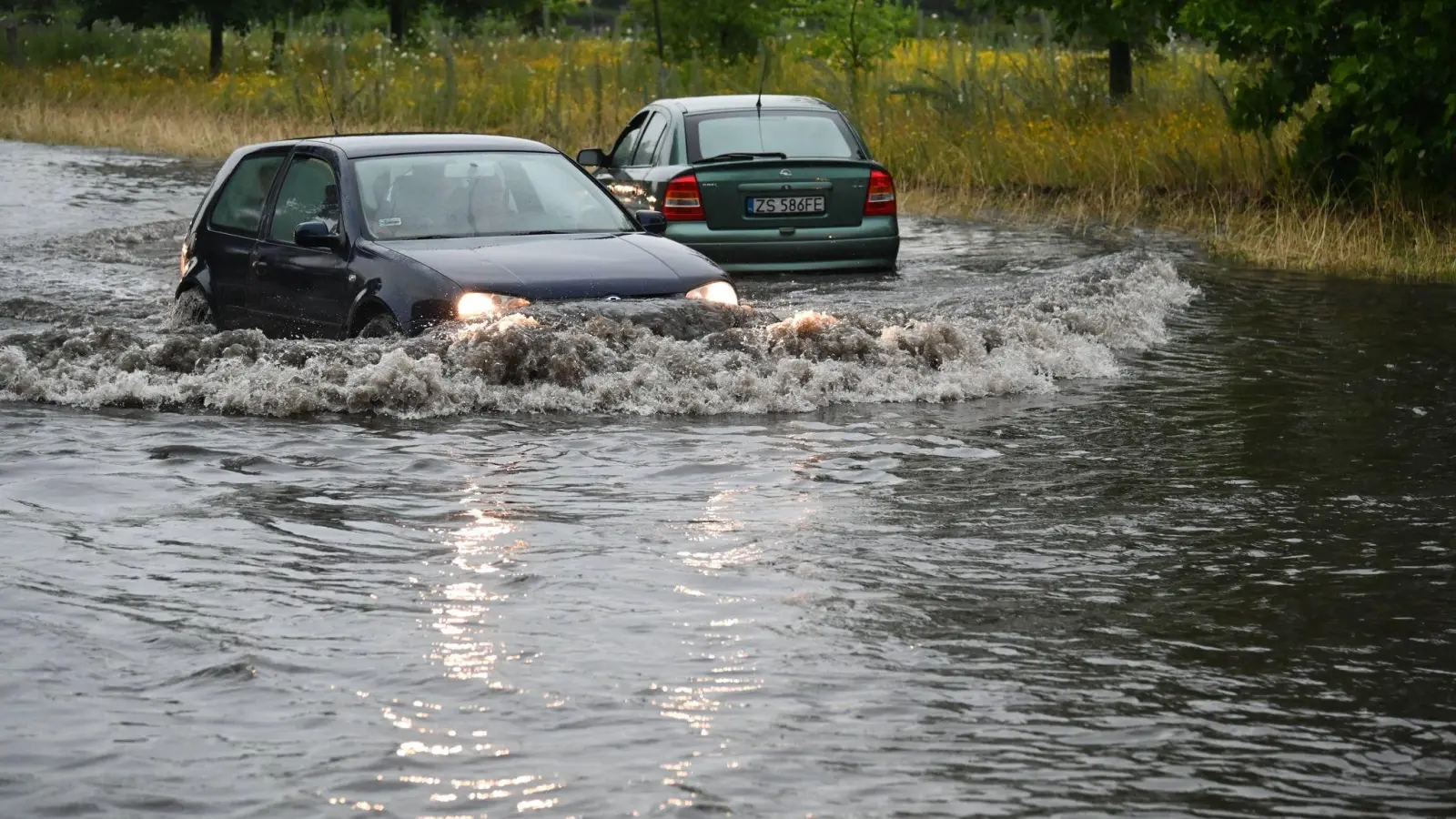 Zwei Autos auf einer überschwemmten Straße in Stettin. (Foto: Marcin Bielecki/PAP/dpa)