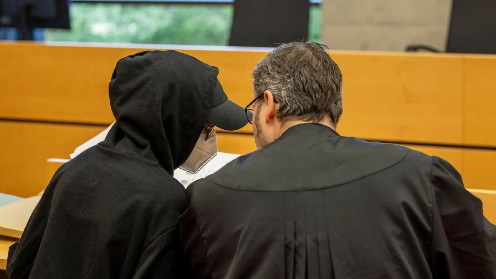 Eine der beiden Angeklagten (l) unterhält sich mit ihrem Rechtsanwalt im Sitzungssaal im Landgericht. (Foto: Heiko Becker/dpa)