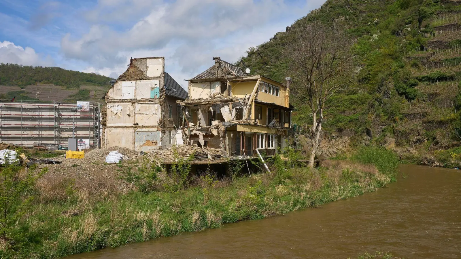 Ein abbruchreifes Haus, das durch die Flut zerstört wurde, steht an einem Ufer. (Foto: Thomas Frey/dpa/Archivbild)