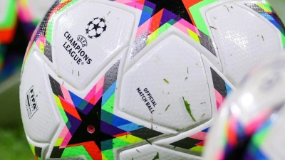 Fußball mit dem Logo der Champions League liegen auf dem Rasen. (Foto: Jan Woitas/dpa)