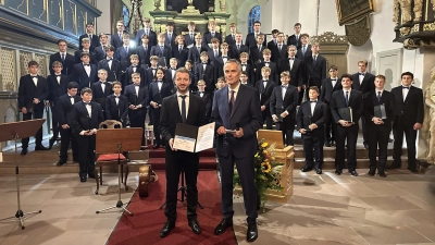 Der Vorsitzende der Brahmsgesellschaft Schleswig-Holstein, Joachim Nerger (re) übergibt den Brahmspreis 2025 an den Leiter des Windsbacher Knabenchors, Ludwig Böhme. (Foto: Andreas Guballa)