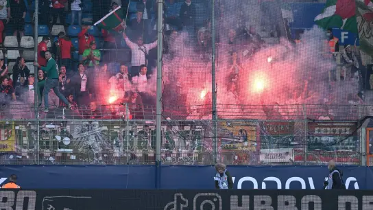Fans des FC Augsburg zünden beim VfL Bochum im Gästeblock Pyrotechnik. (Foto: David Inderlied/dpa)