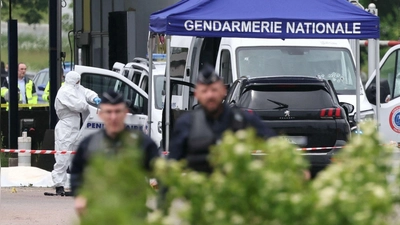 Gerichtsmediziner und Polizisten am Ort des Angriffs an einer Mautstelle in Nordfrankreich. (Foto: Alain Jocard/AFP/dpa)