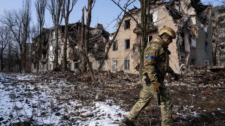 Ein ukrainischer Soldat vor einem zerstörten Wohnhaus in der ostukrainischen Stadt Awdijiwka. (Foto: Evgeniy Maloletka/AP/dpa)