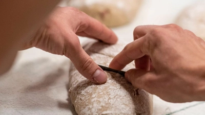 Ein Bäckergeselle arbeitet in Berlin an einem Brot. (Foto: Fabian Sommer/dpa/Archivbild)