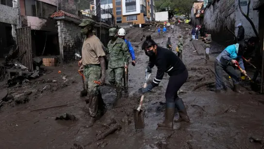Anwohner und Soldaten arbeiten daran, die Straßen in der Hauptstadt Quito von Schlamm zu befreien. (Foto: Dolores Ochoa/AP/dpa)