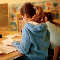 Damit sich links- und rechtshändige Schulkinder nicht mit den Ellenbogen ins Gehege kommen, sollte ein Linkshänder auf der linken Seite und der Rechtshänder auf der rechten Seite daneben sitzen. (Foto: Oliver Berg/dpa/dpa-tmn)