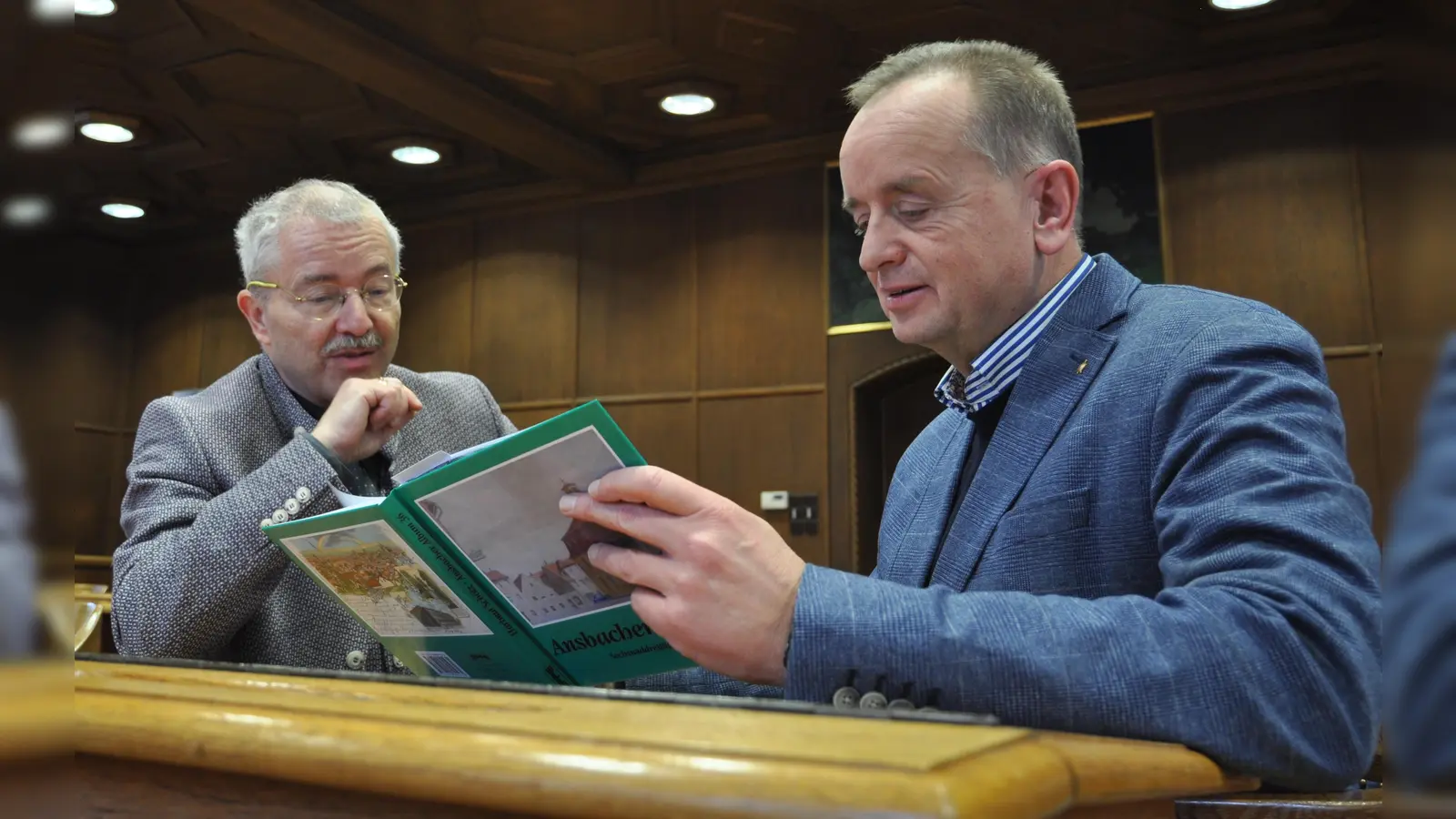 Als „alter Ansbacher“ entdeckte OB Thomas Deffner (rechts) viele Ansichten seiner Kindheit in dem Buch von Hartmut Schötz. (Foto: Jonas Volland)