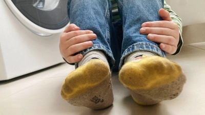 Nach einem Tag auf dem Spielplatz des Kindergartens: Das sind die vielleicht dreckigsten Socken der Welt.  (Foto: Simone A. Mayer/dpa-tmn)