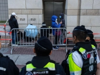 Menschen warten vor dem West Kowloon Magistrates' Courts auf die Urteilsverkündung gegen den Hongkonger Aktivisten und Verleger Jimmy Lai. (Foto: Chan Long Hei/AP/dpa)