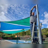 Bereit für den Winter: Stefan Keller nimmt das Sonnensegel am Kinderplanschbecken im Burgbernheimer Freibad. (Foto: Katrin Merklein)