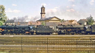 Am Ende der Dampf-Ära: Zwei Lokomotiven der Baureihe 01 Mitte der 1960er-Jahre am Bahnhof in Ansbach – im Hintergrund die katholische Kirche St. Ludwig. (Foto: Siegfried Tappert)