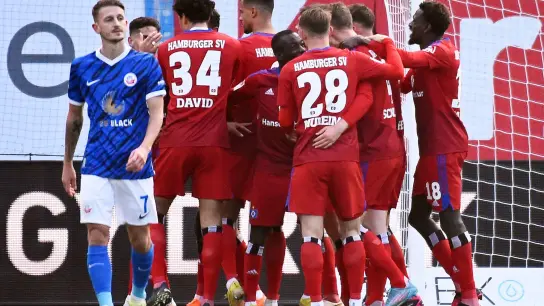 Die Hamburger Spieler feiern das 1:0 bei Hansa Rostock. (Foto: Gregor Fischer/dpa)