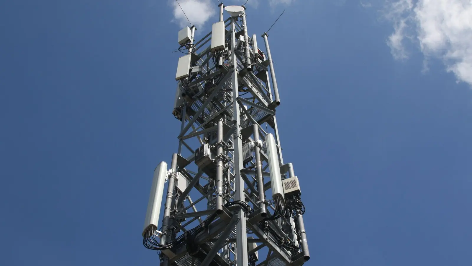 Ein Mobilfunkmast mit Antennen für den Funkstandard 5G (oben) und für LTE/4G (unten). (Foto: Christoph Dernbach/dpa)