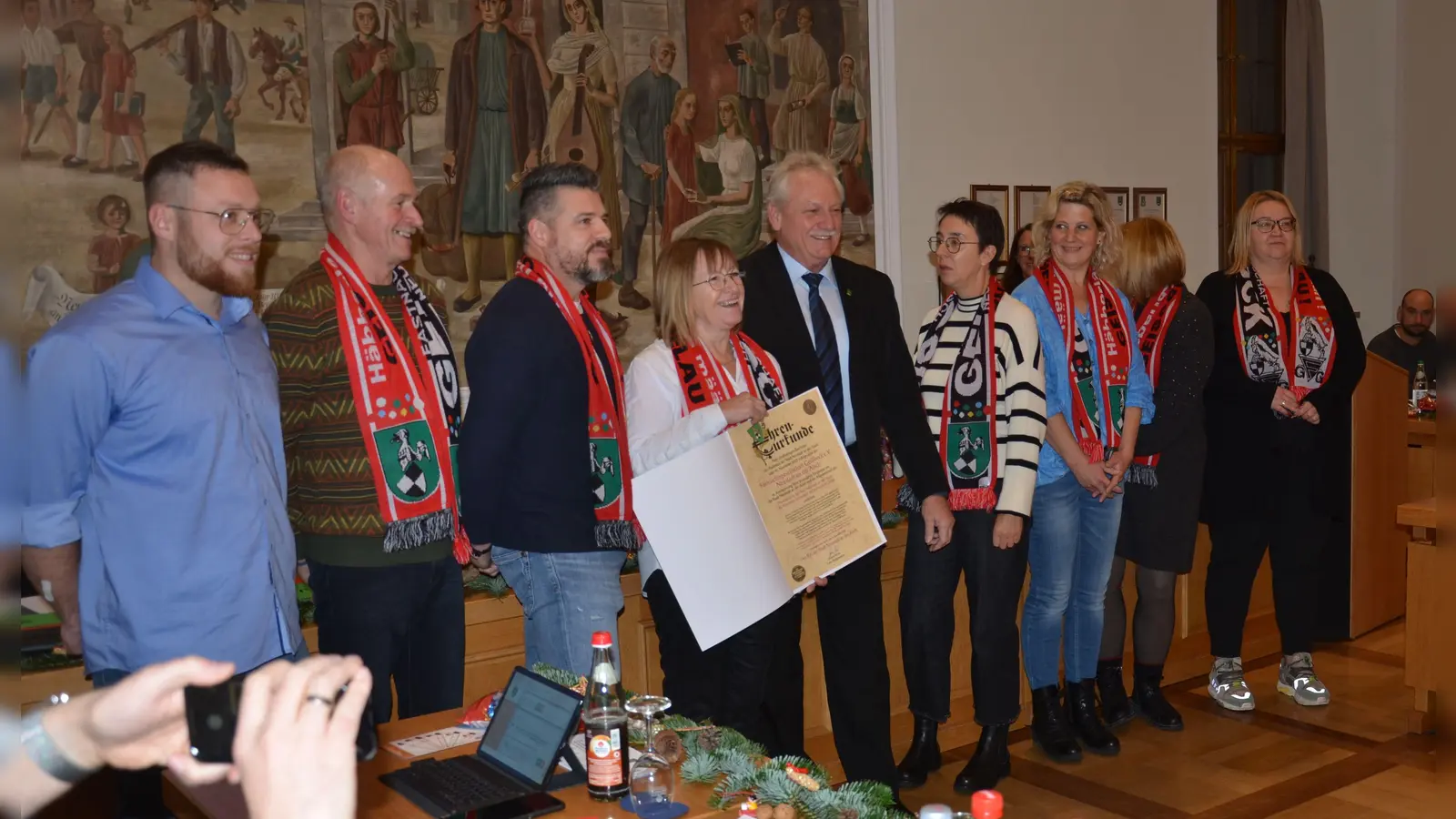 Sichtlich stolz nahm Sylvia Seeberger (Vierte von links), Vorsitzende der Geißböcke, die Ehrenmedaille und die dazu gehörige Urkunde für „besondere Leistungen auf kulturellem Gebiet“ aus den Händen von Bürgermeister Klaus Meier (Fünfter von links) entgegen. (Foto: Patrick Lauer)