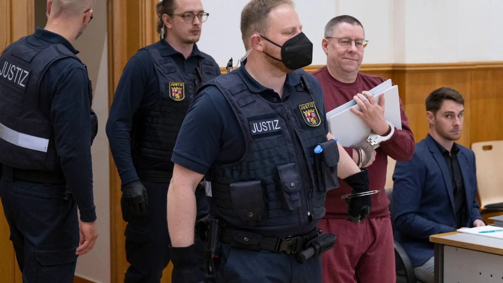 Zum Prozessauftakt wird der Angeklagte Sven Birkmann in Handschellen in den Gerichtssaal geführt. (Foto: Boris Roessler/dpa)