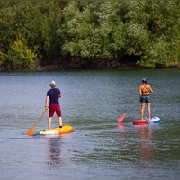 Das Stehen auf einem SUP-Board fordert Muskeln in Rumpf, Beinen und Füßen. (Foto: Thomas Banneyer/dpa/dpa-tmn)