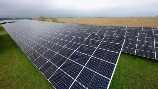 Solaranlagen sind für ein Photovoltaik-Speicher-Kraftwerk auf einer Wiese montiert. (Foto: Robert Michael/dpa)