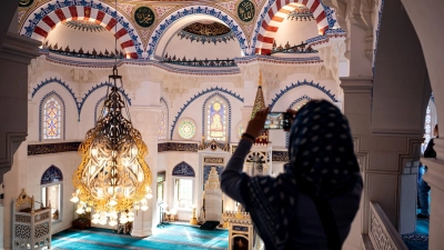 Eine Besucherin fotografiert die Sehetlik-Moschee am Columbiadamm in Berlin. (Foto: Fabian Sommer/dpa)