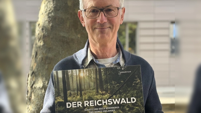 Der Fotograf Gerhard Illig mit seinem druckfrischen Bildband über den Nürnberger Reichswald.  (Foto: Lara Hausleitner)