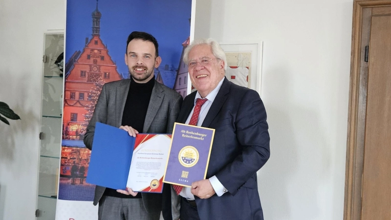 Oberbürgermeister Christoph Rösch (links) freut sich über die von Burkhard Graf Beissel von Gymnich überbrachte Auszeichnung des Reiterlesmarkts.  (Foto: Rothenburg Tourismus Service / Robert Nehr)