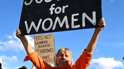 In Canberra fordert eine Frau „Justice for Women” (Gerechtigkeit für Frauen). (Foto: Lukas Coch/AAP/dpa)