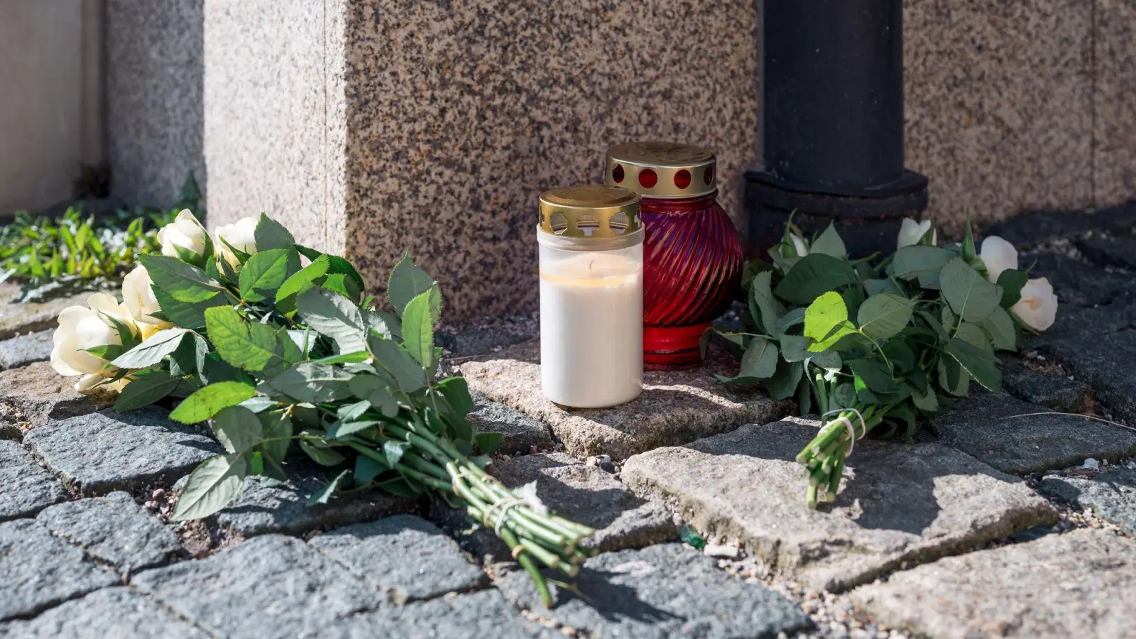 Blumen an der Zufahrtsstraße zum Kinder- und Jugendhilfezentrum in Wunsiedel, wo eine Zehnjährige tot aufgefunden wurde. (Foto: Daniel Vogl/dpa)